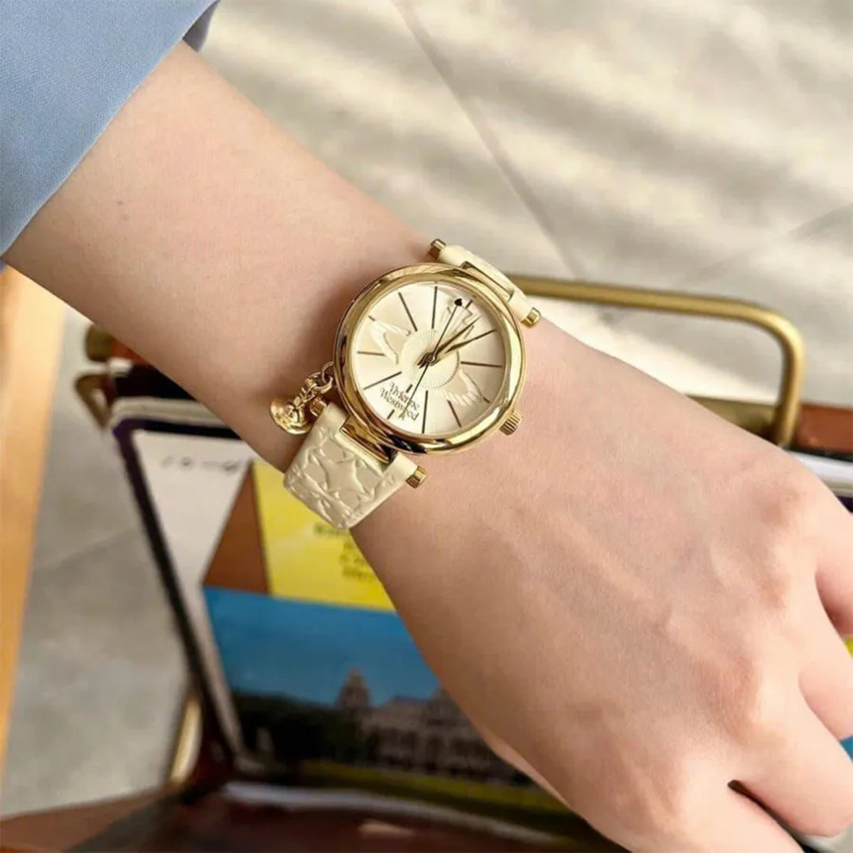 Vivienne Westwood ladies quartz watch with gold-tone case, beige dial, and white leather strap