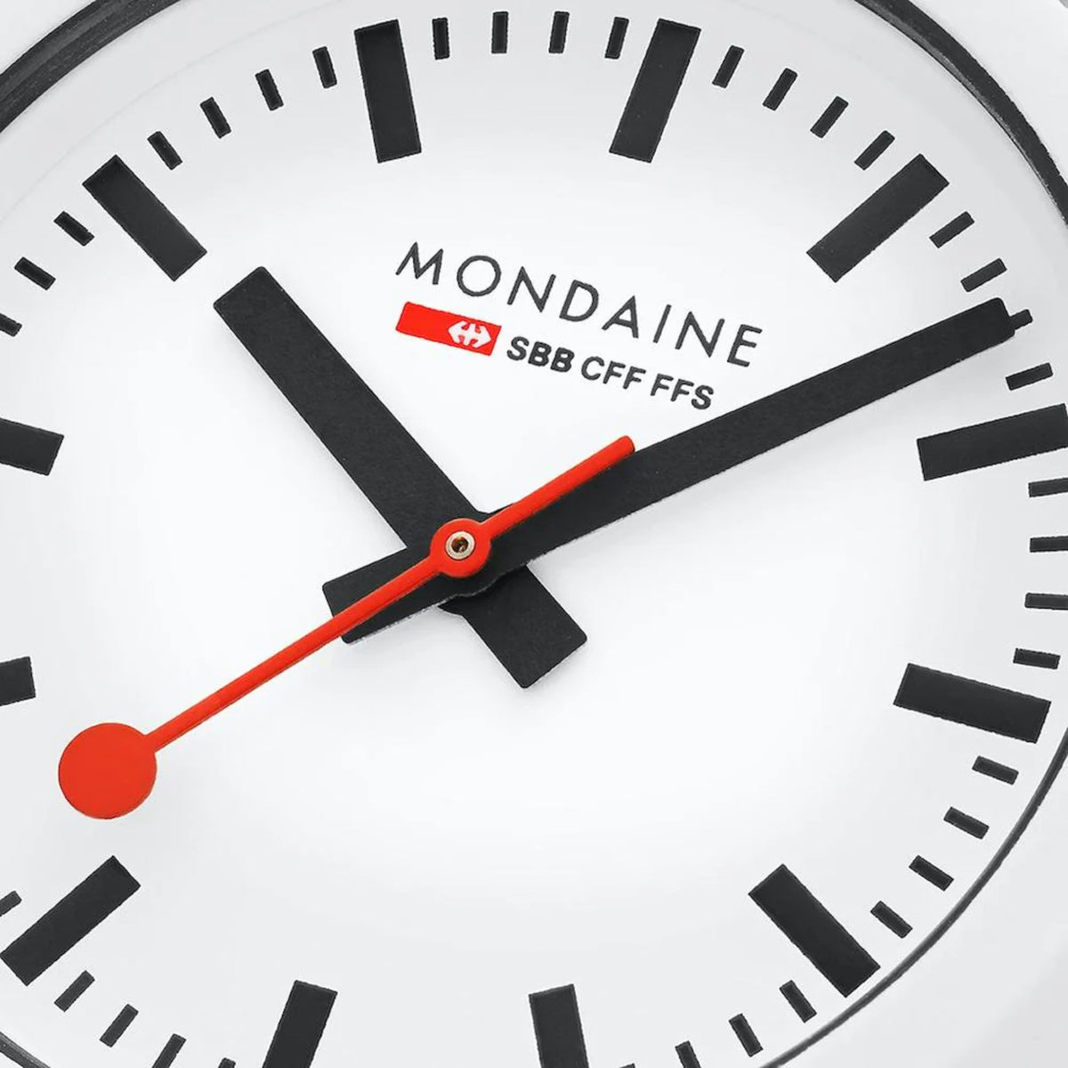 Close-up of white watch dial with black numerals and orange hands