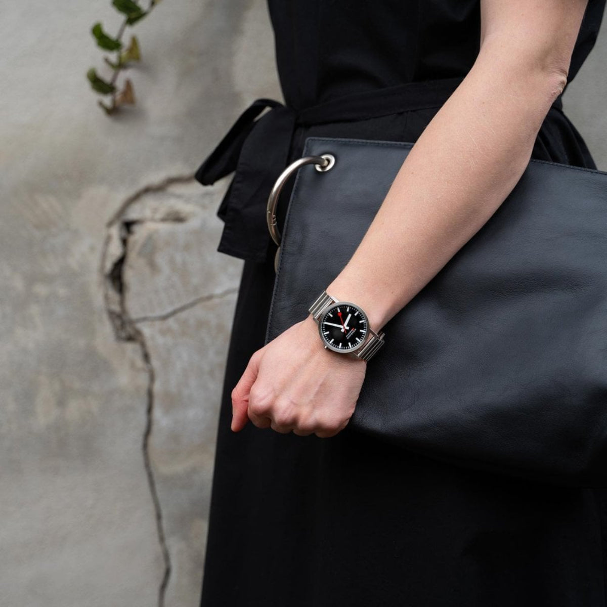 Unisex stainless steel watch on wrist with black dial and metal bracelet