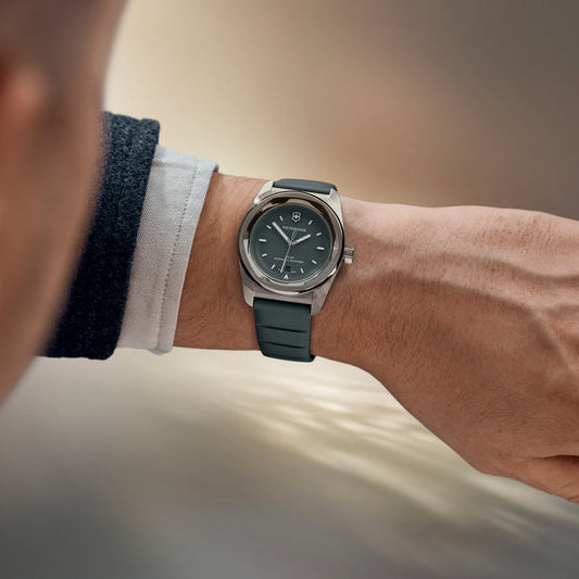 Men's wrist wearing Victorinox Concept One Solar watch with dark grey rubber strap