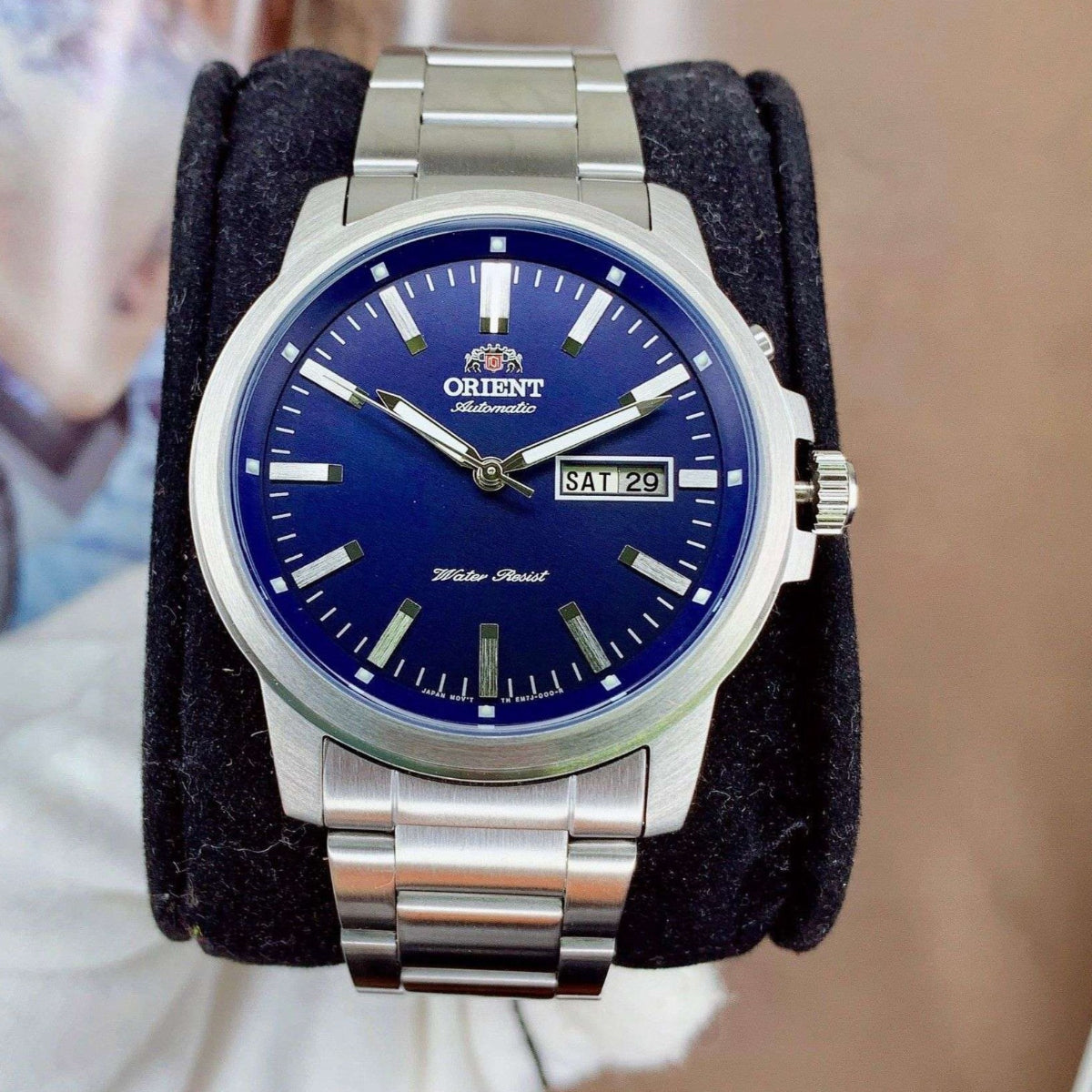 Orient Contemporary RA-AA0C02L39B watch with blue dial and silver bracelet on a blurred background