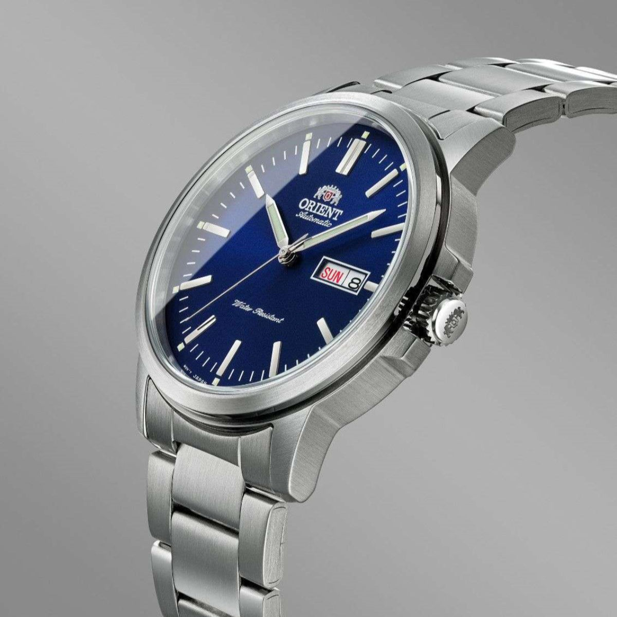 Orient Contemporary RA-AA0C02L39B wristwatch showing its blue dial, day-date window, crown, and stainless steel bracelet on a grey background