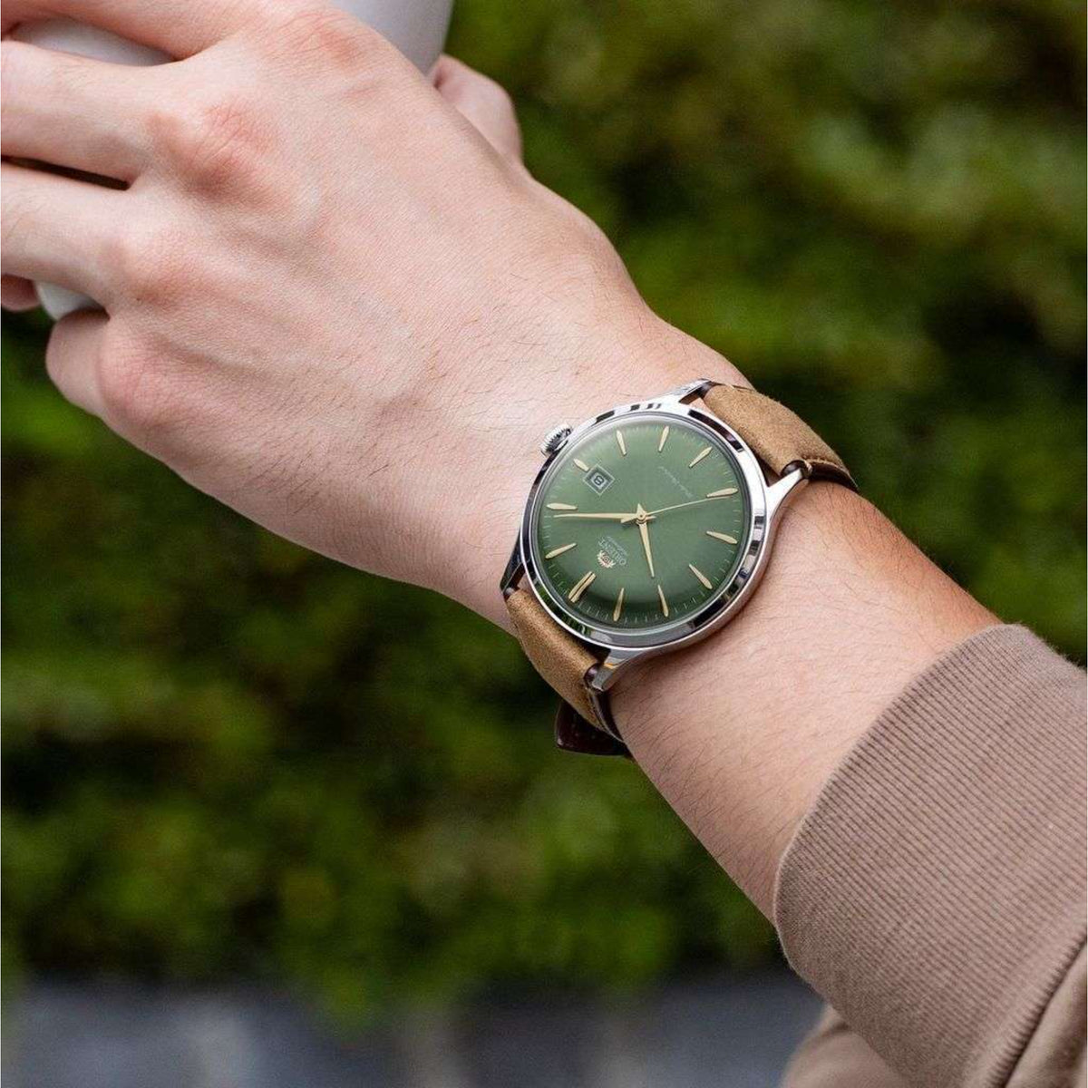 Orient Bambino RA-AC0P01E30B mens wrist watch featuring stainless steel case, green face, and brown leather strap on wrist