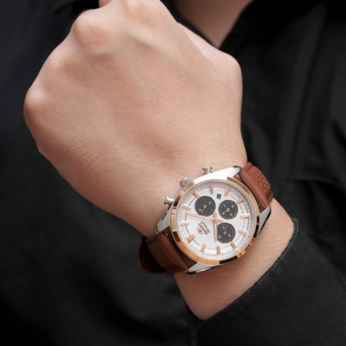Men's solar chronograph watch with white dial and brown leather strap on wrist
