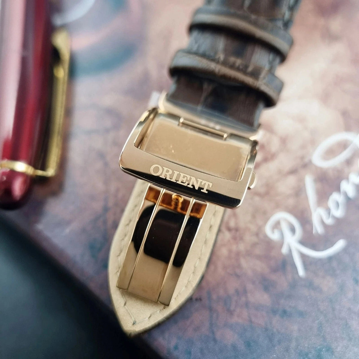 Orient Bambino Sun and Moon brown leather strap with gold-tone clasp labeled ORIENT