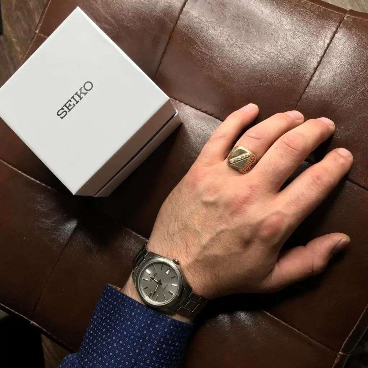 Seiko titanium quartz watch on wrist, silver dial with baton markers and date