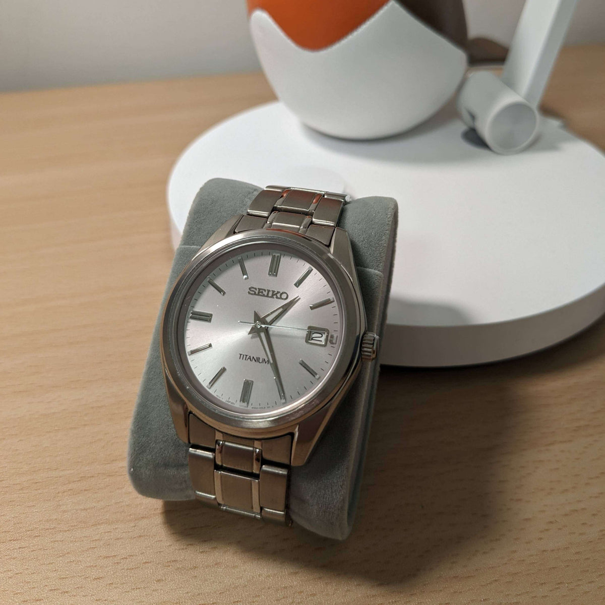 Seiko titanium quartz watch, silver dial and metal bracelet on display stand