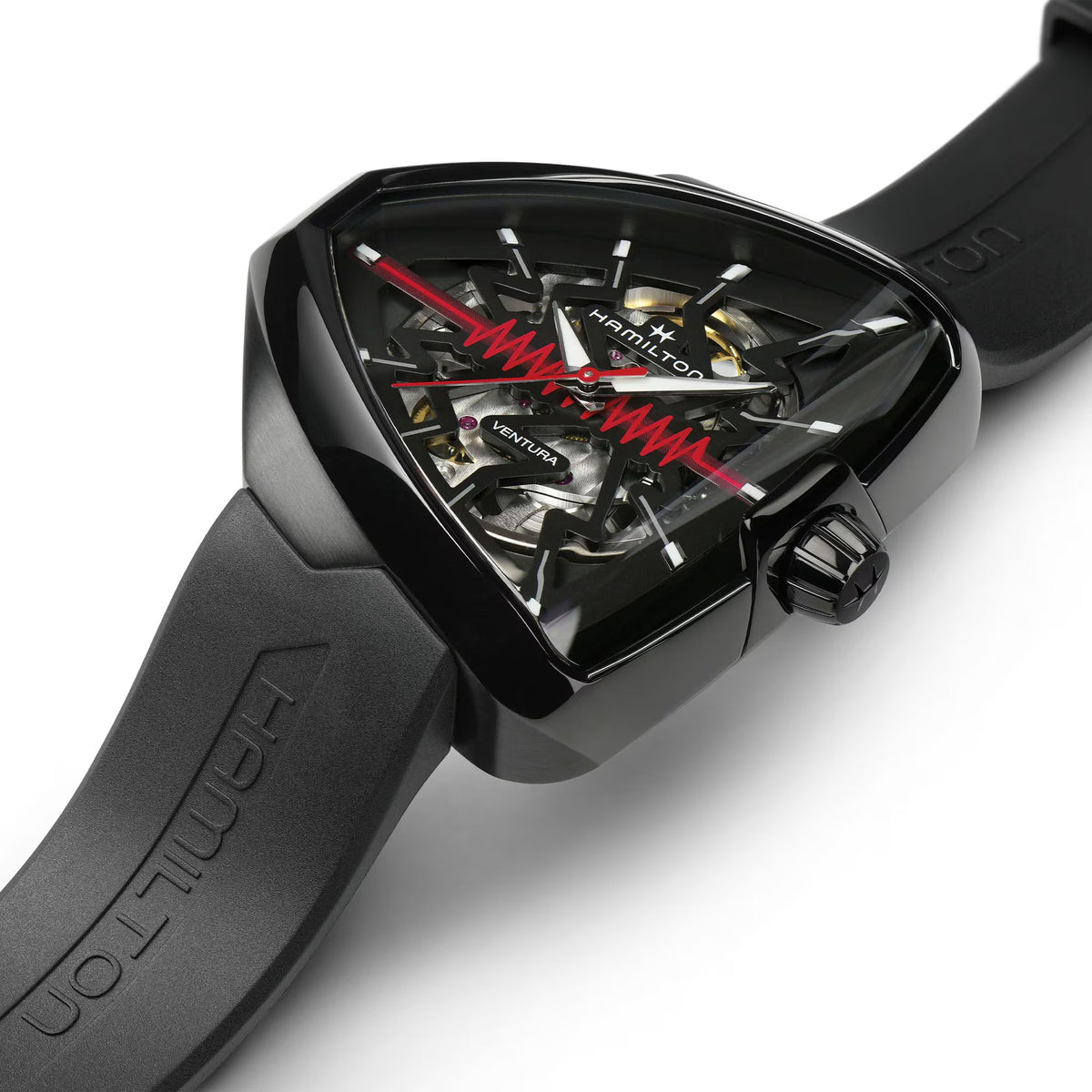Close-up of black skeleton automatic watch with red accents on black rubber strap