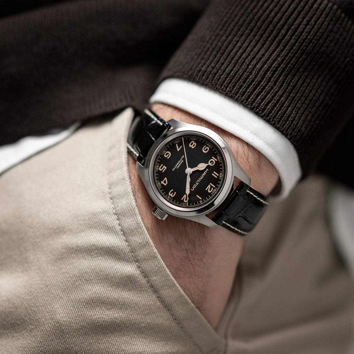 Hamilton Khaki Field Murph H70405730 automatic watch wrist shot styled with brown sweater showing black dial and leather strap