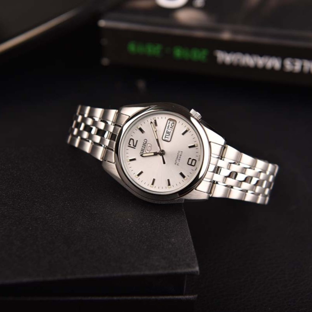 Seiko 5 stainless steel watch SNK385K1 on display with a silver dial and metal bracelet