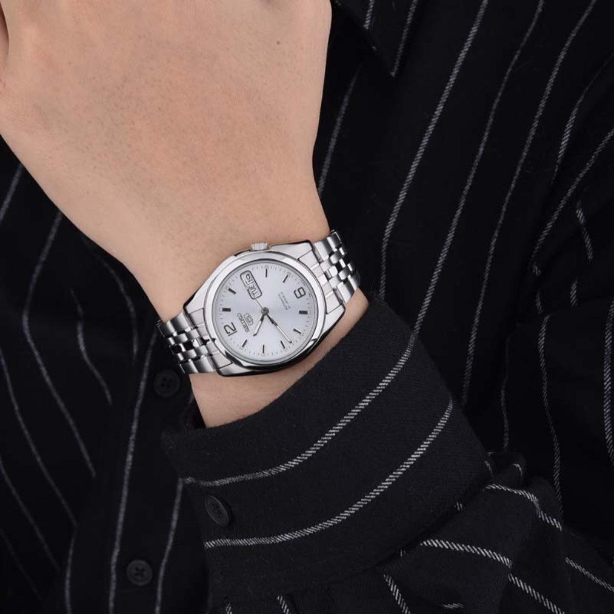 Seiko 5 SNK385K1 stainless steel watch on wrist with silver dial and metal bracelet