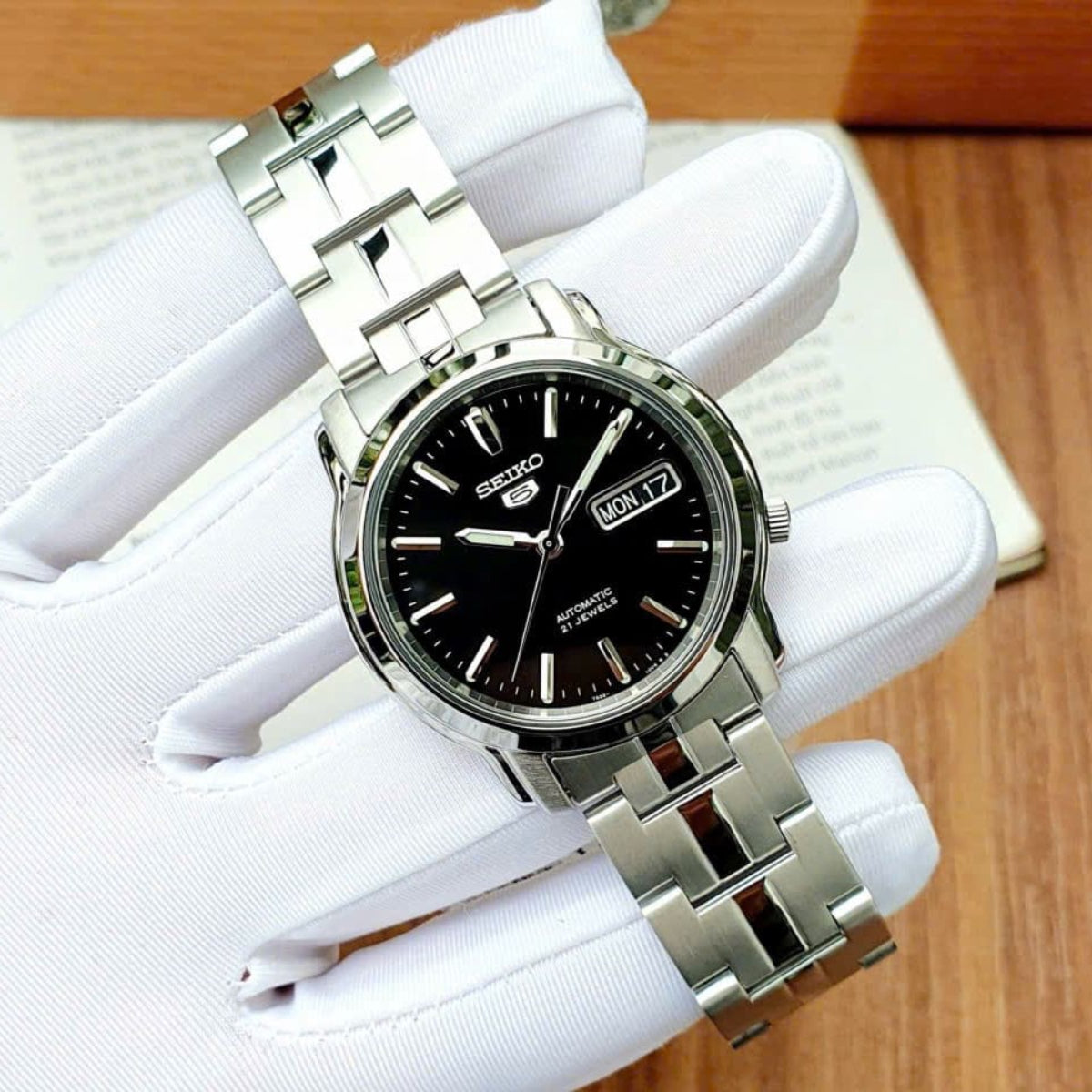 Seiko 5 Classic SNKK71K1 angled shot of black dial featuring stainless steel casing