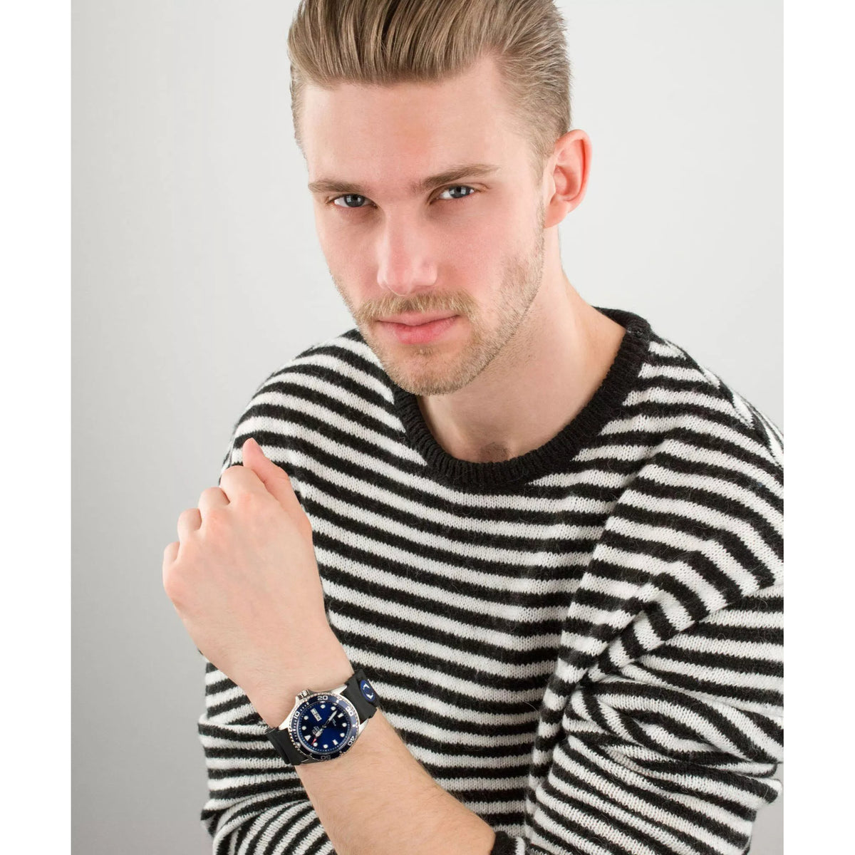 Automatic dive watch on wrist, blue dial with date window, black silicone strap