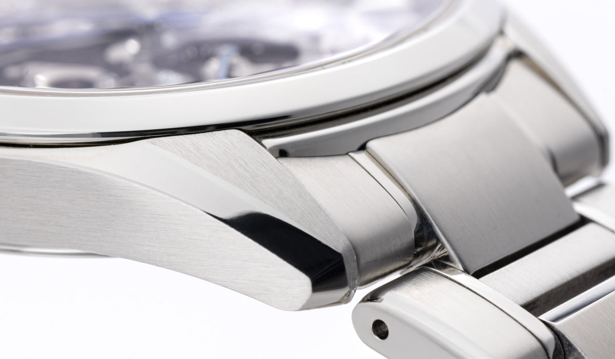 Close-up of a brushed stainless steel Orient Star watch case lug and bracelet link end showing fine Zaratsu polishing