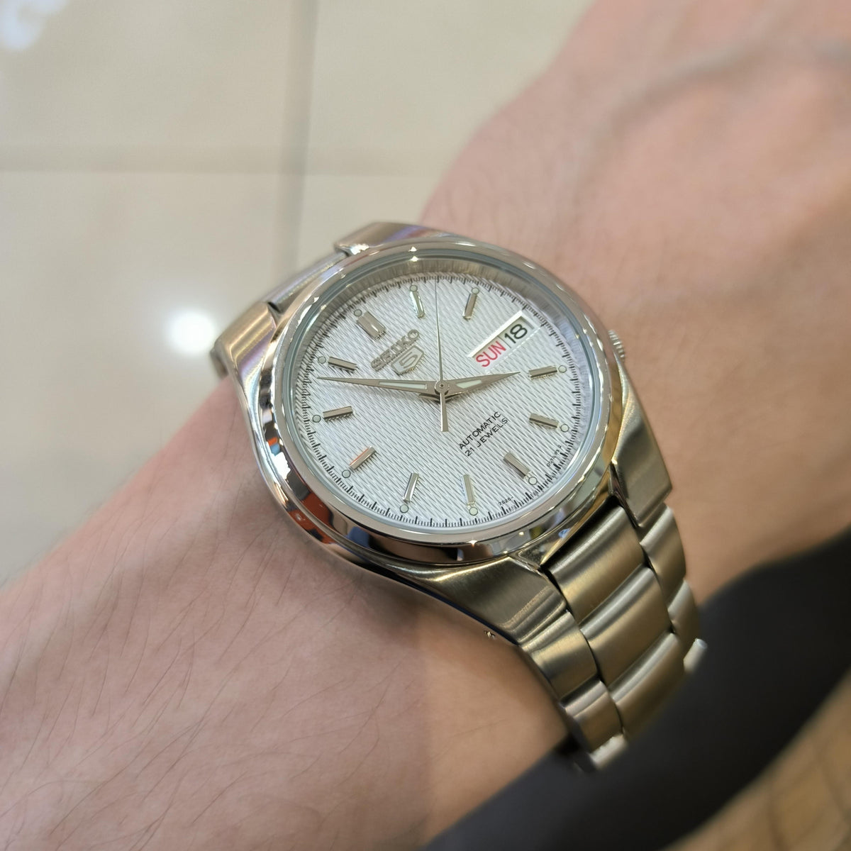 Seiko 5 SNK601K1 mens wristwatch with white dial displayed on a wrist