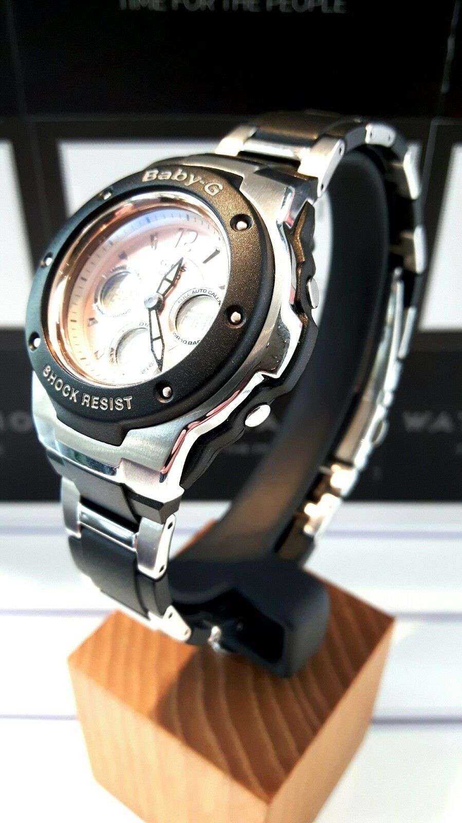 Baby-G women's wristwatch side view, silver metal case and black resin strap