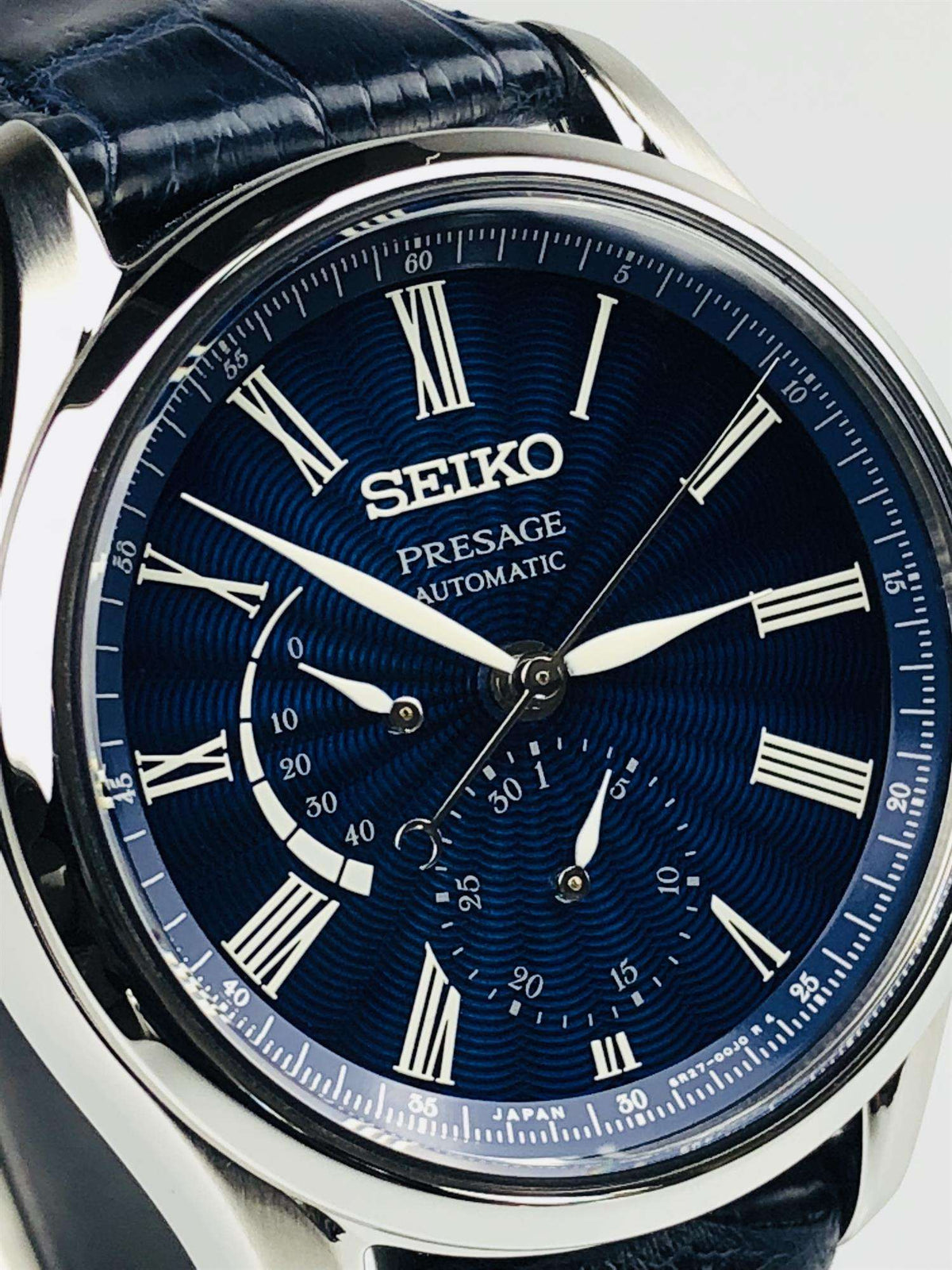 Seiko Presage automatic watch dial close-up with blue wave texture, Roman numerals, subdials