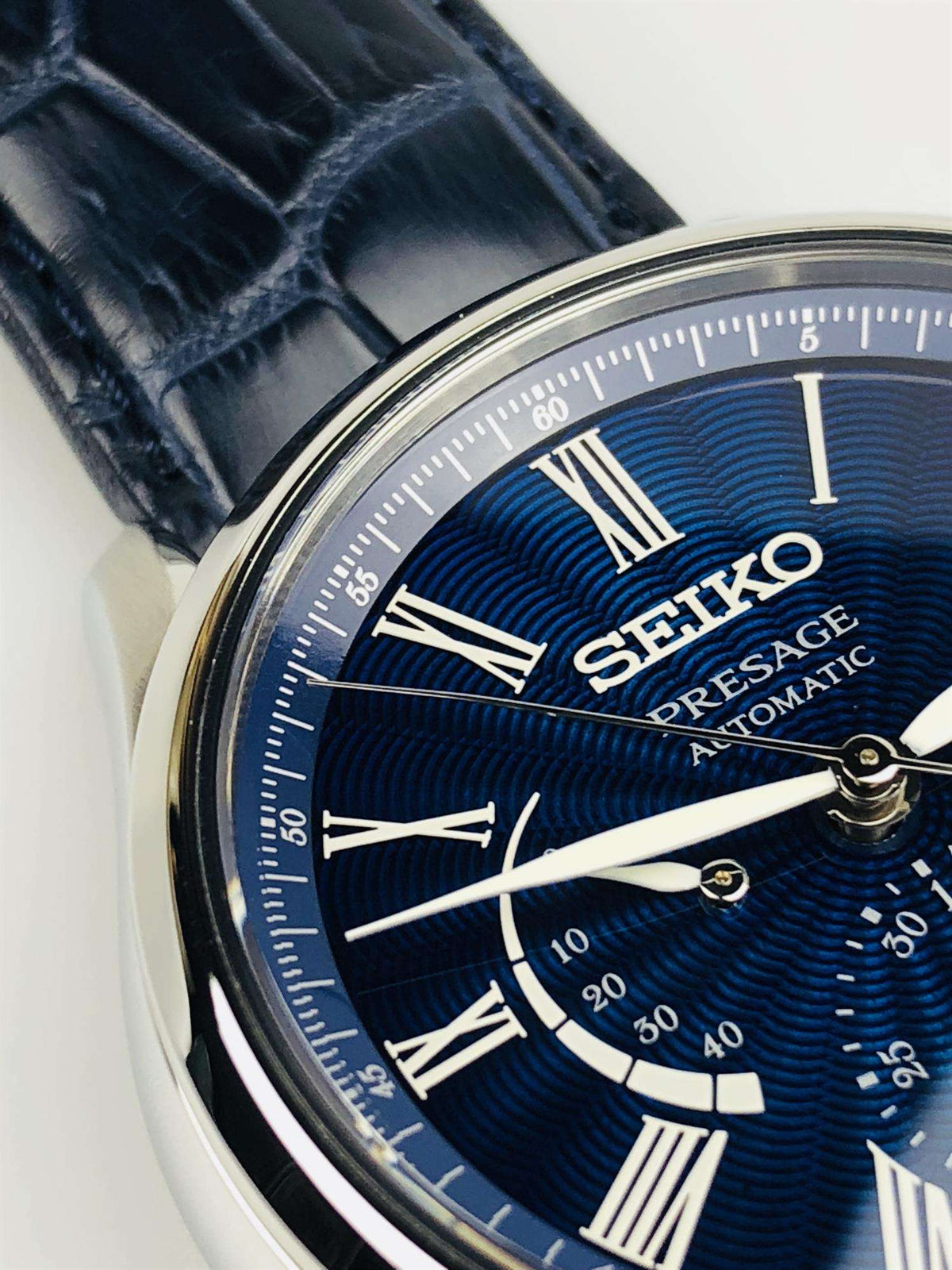 Seiko Presage automatic watch dial detail with blue textured finish, Roman numerals, hands