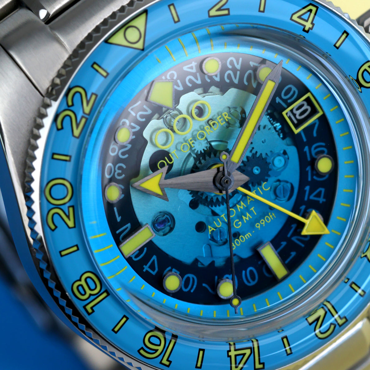 Men's automatic GMT watch, blue dial with yellow hands and bezel numerals, steel bracelet
