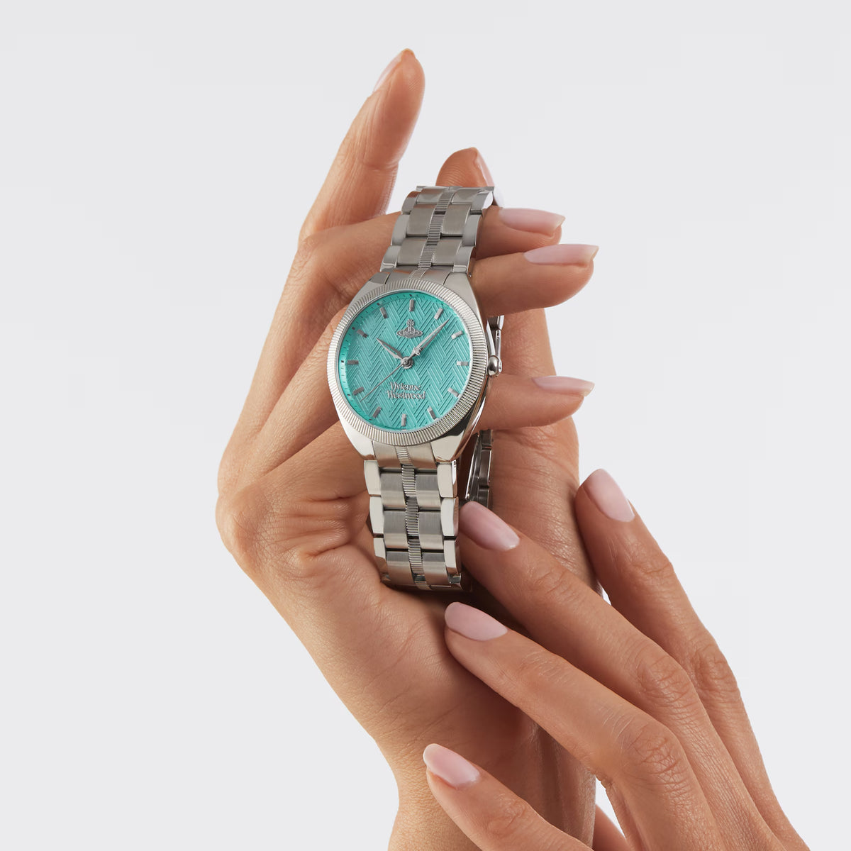 Turquoise dial stainless steel bracelet watch held in hands