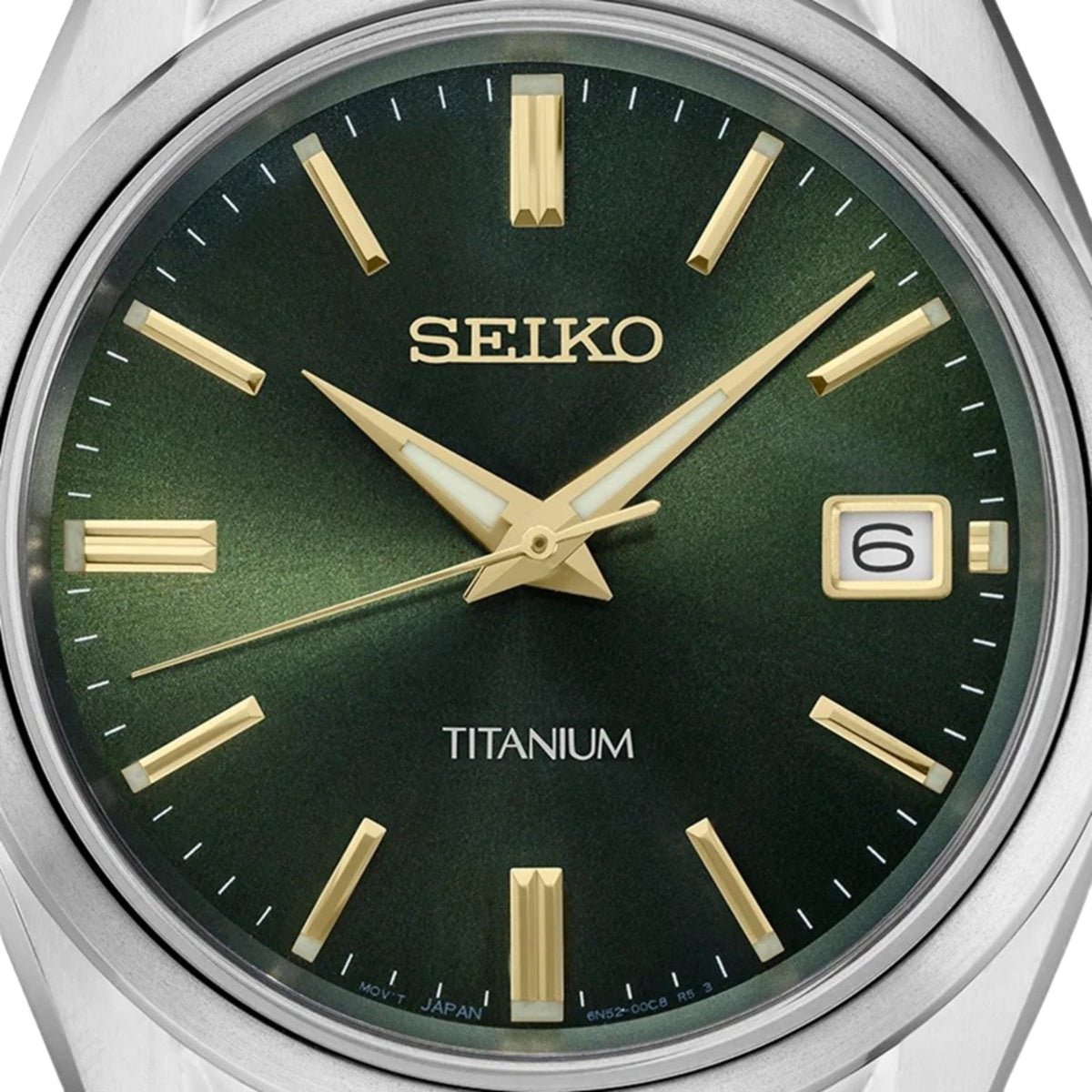 Detailed view of the dark green dial on the Seiko Essentials SUR377P1 luxury timepiece with gold indices, luminous hands, and a date display window.