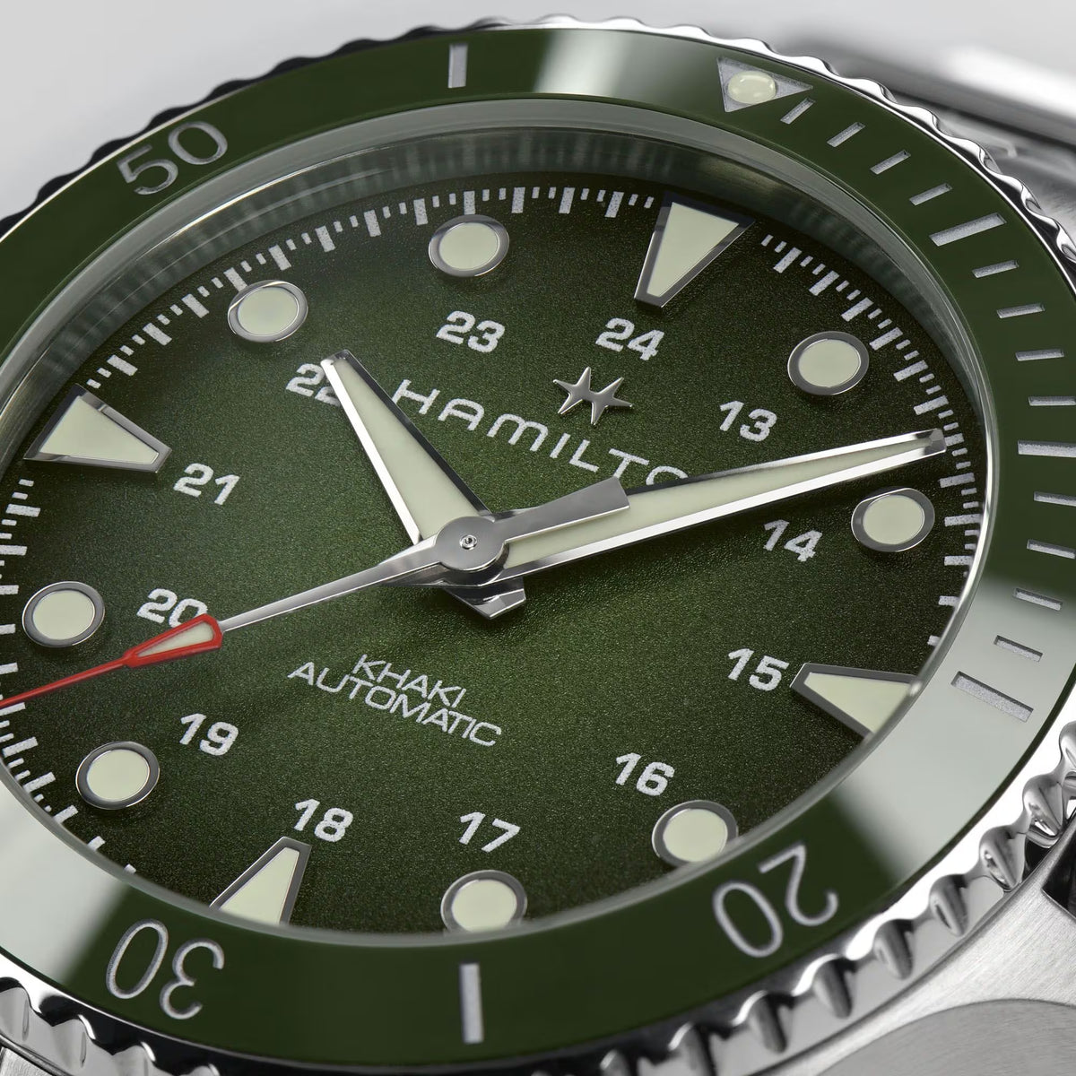 Hamilton Khaki Navy Scuba H82525160 mens watch macro detail highlighting green dial texture, luminous indices, and ceramic bezel insert