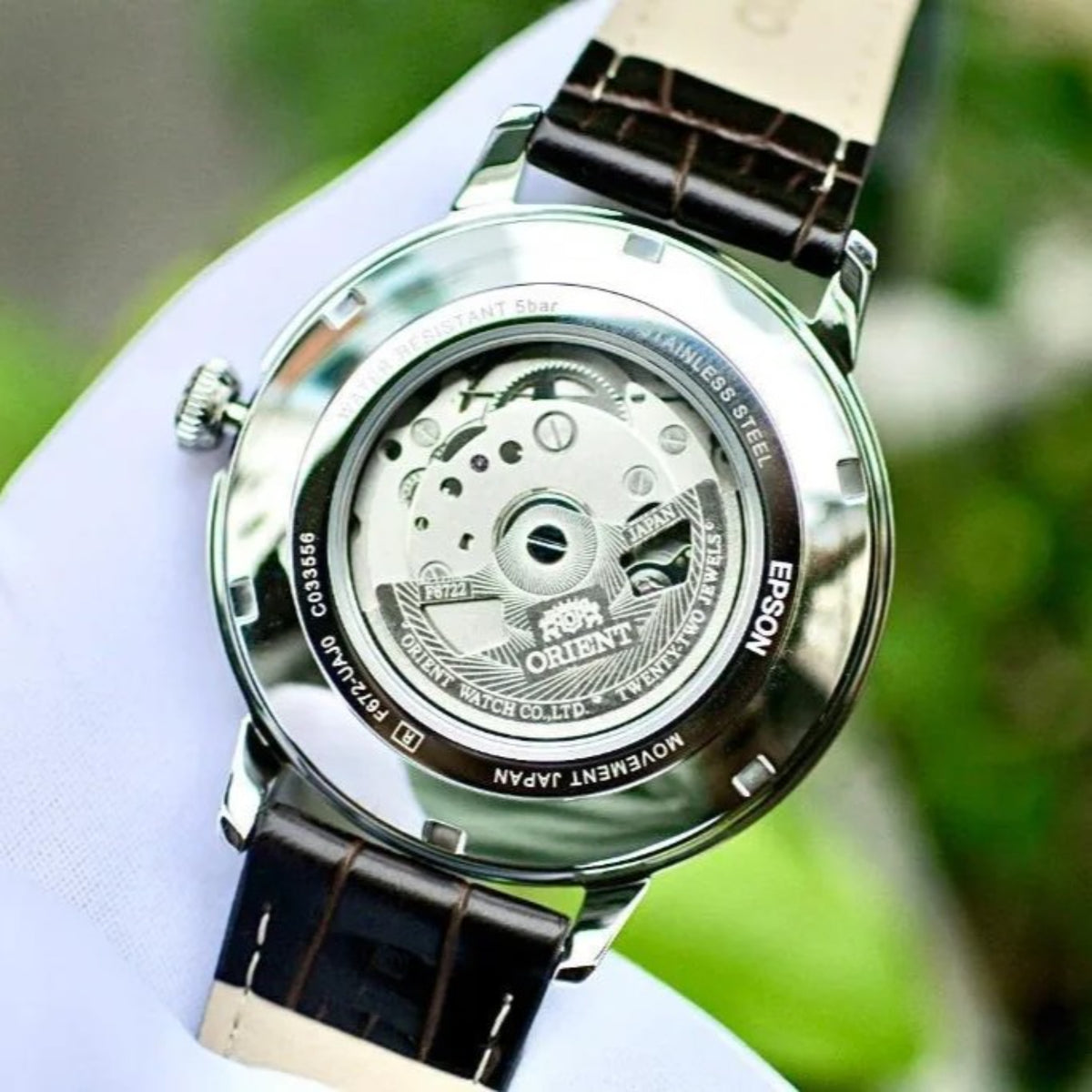Men's automatic watch caseback with engraved stainless steel back and leather strap