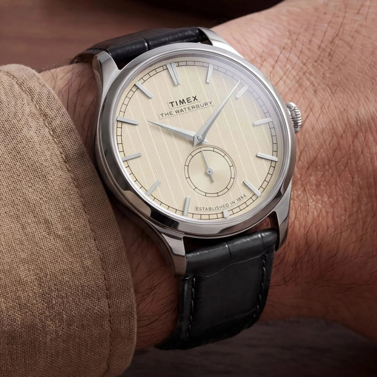 Timex Waterbury TW2Y92000 wrist view showing a white dial quartz watch styled on a person wearing a leather strap