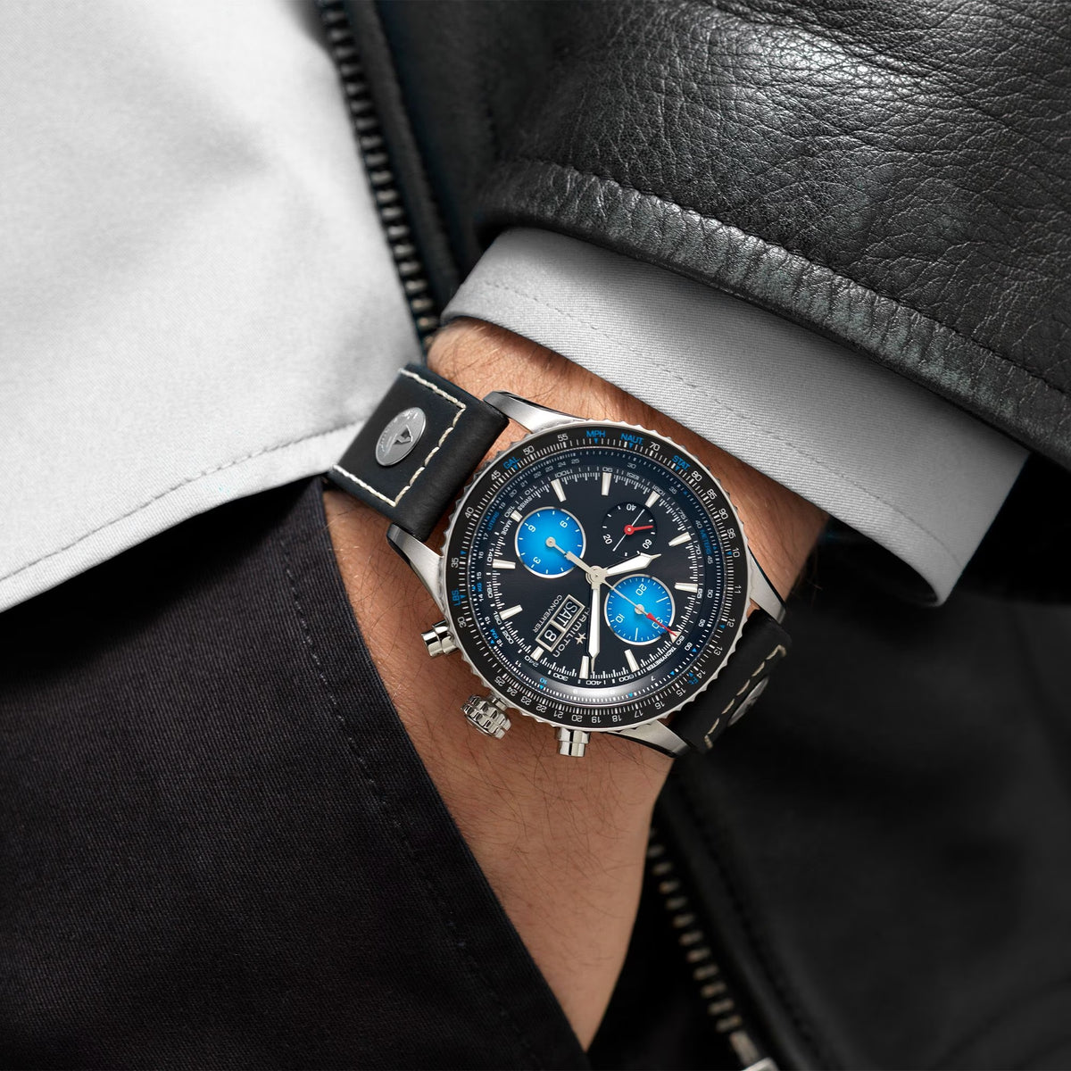 Men's automatic pilot watch on wrist with black leather strap and blue-accented dial