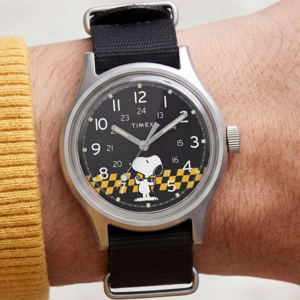 Timex Peanuts MK1 TW2Y85400 wrist view showing black dial casual watch styled on a person wearing a textile strap