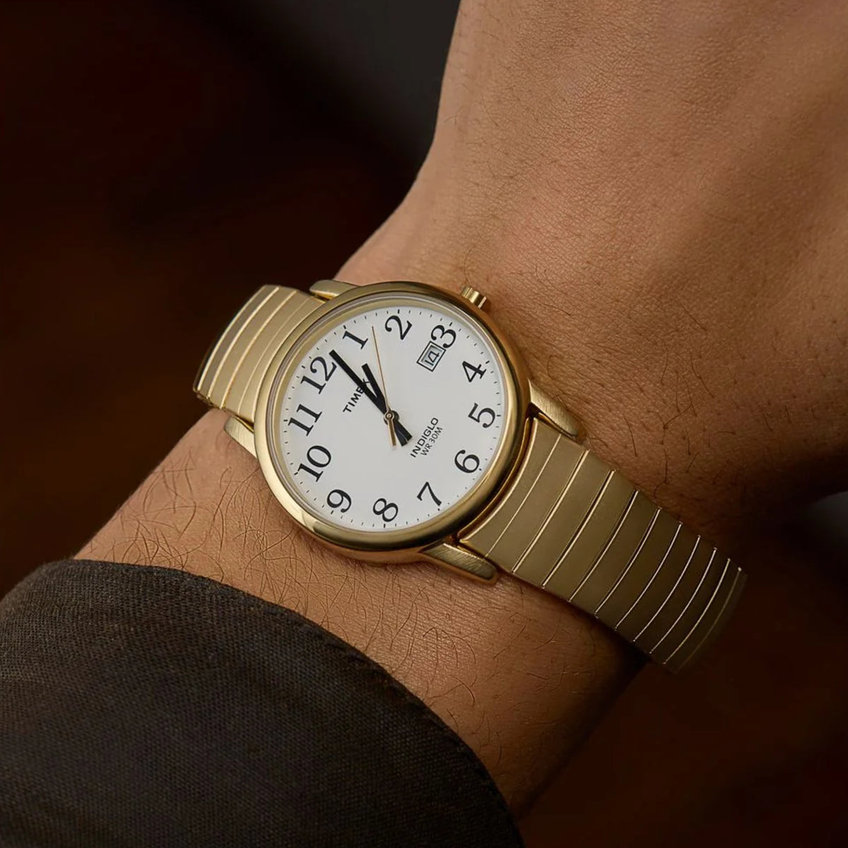 Timex Easy Reader T2H301 wrist view showing a white dial mens watch styled on a person wearing a yellow gold-tone steel expansion band