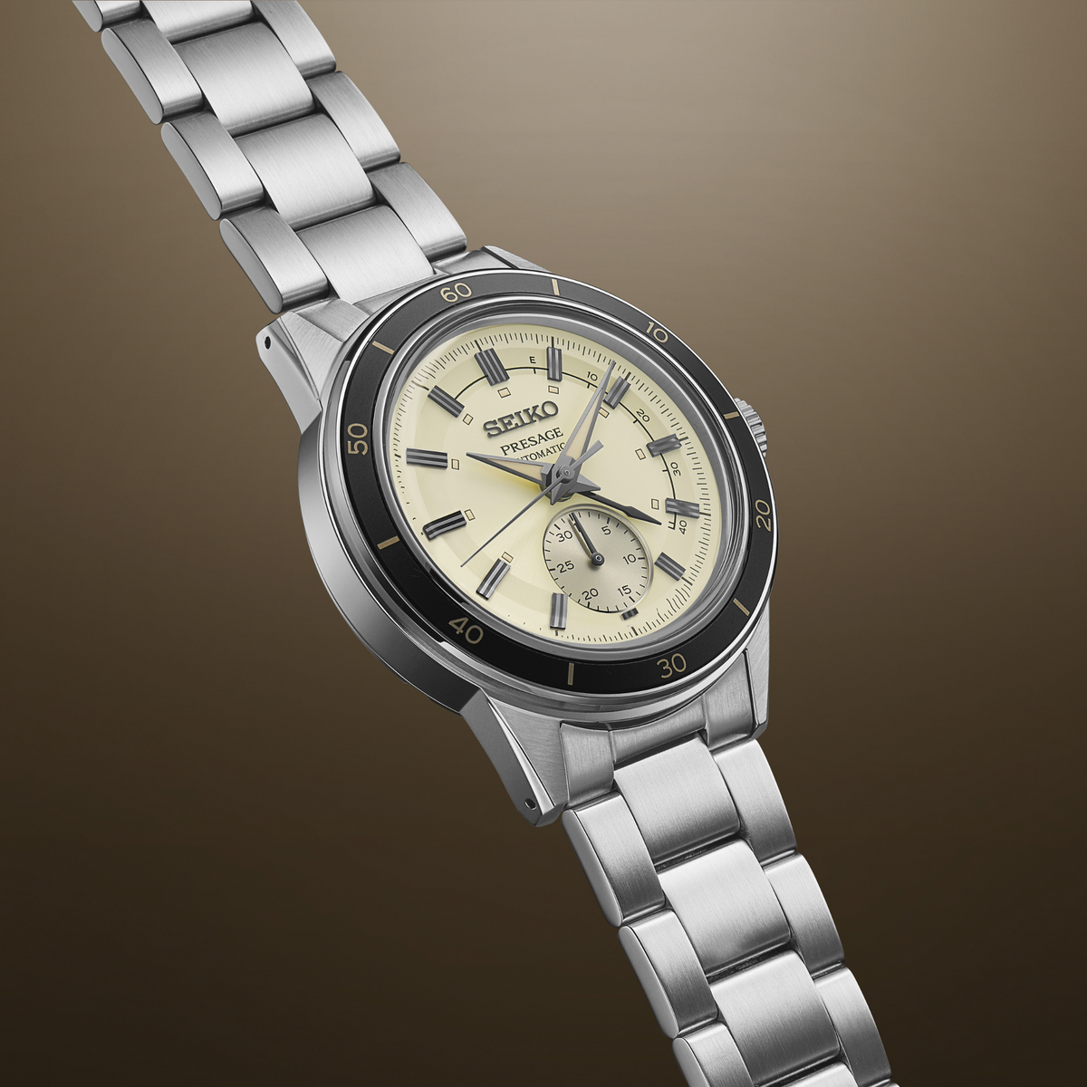 Men's stainless steel automatic watch with ivory dial, black bezel, and brushed bracelet