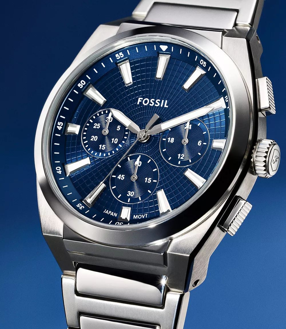Fossil Machine blue dial chronograph watch close-up featuring sub-dials, luminescent hands, textured inner ring, and steel case