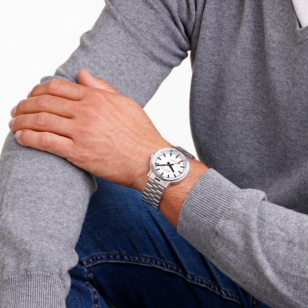 Stainless steel automatic watch on wrist with white dial and metal bracelet