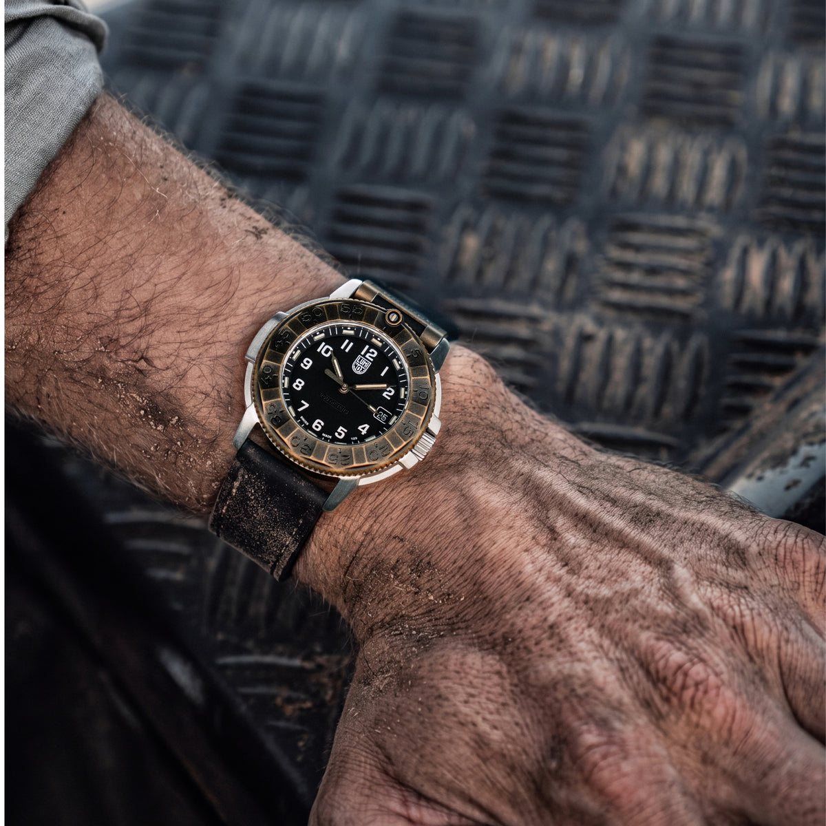 Overhead shot of the Luminox Adventure watch XL.1301 on a wrist against a black metal diamond plate background
