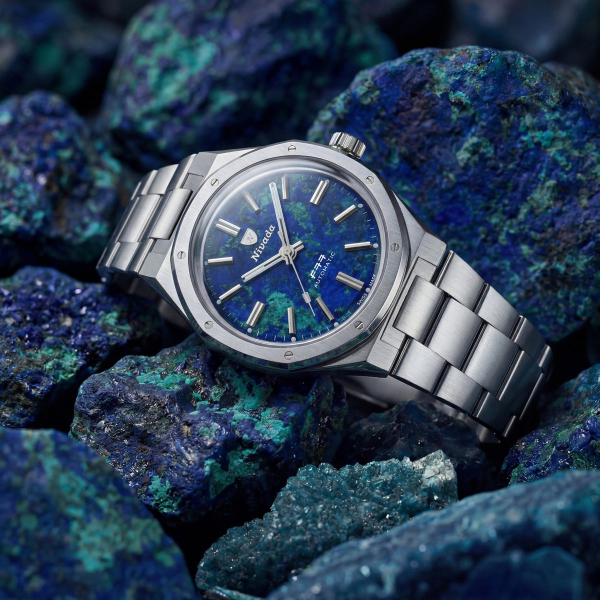 Nivada Grenchen F77 68056A77 angled view resting on raw stones showing azurite dial and polished steel case