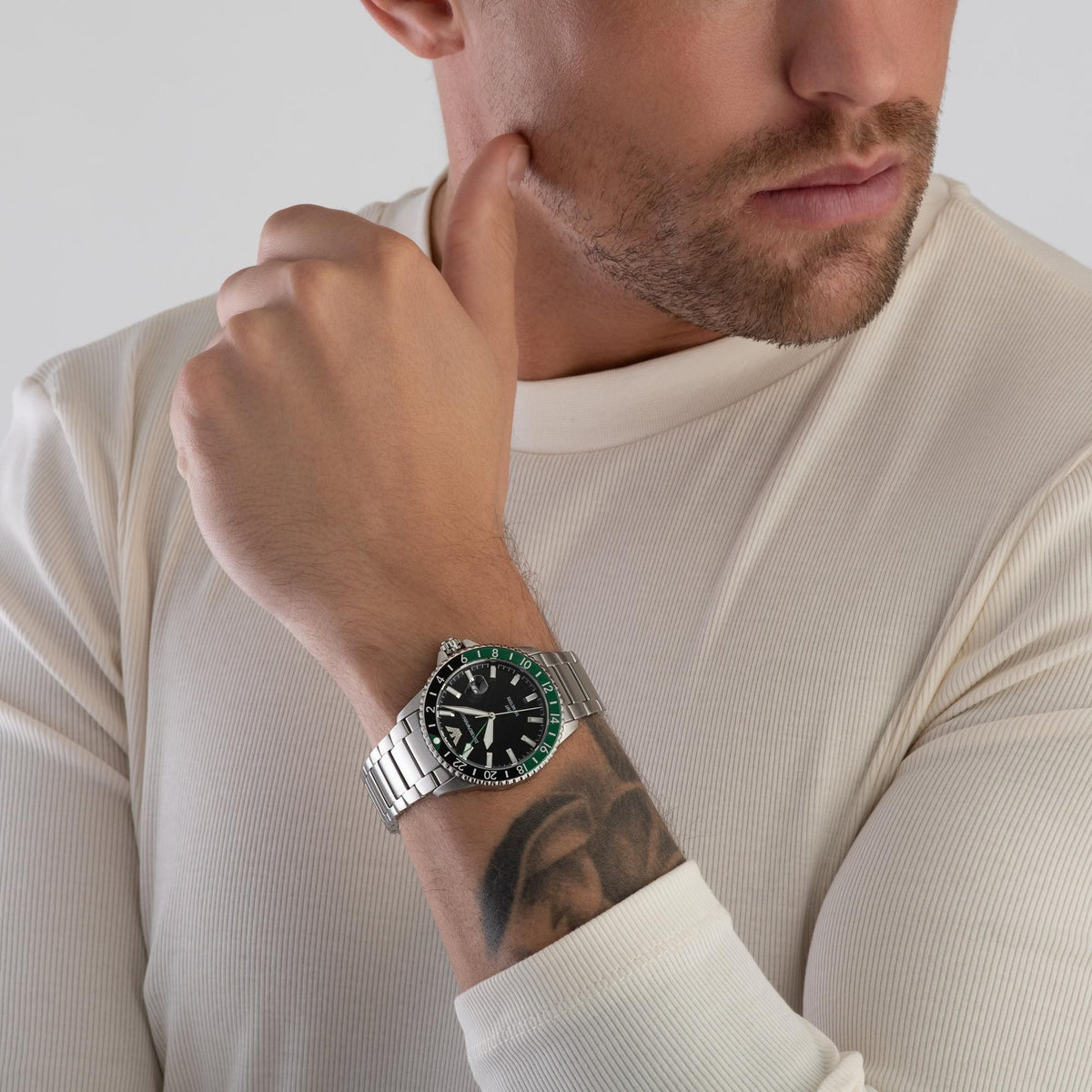 Men's steel quartz watch with black dial and green bezel, stainless link bracelet