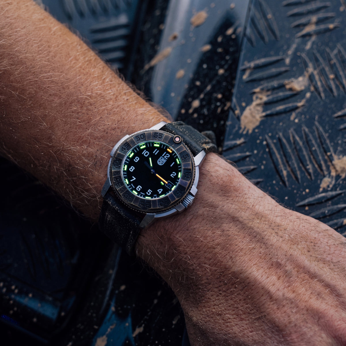 Close-up of the Luminox Adventure Watch XL.1301 watch in low light, highlighting its green and orange glowing tritium dial markers.