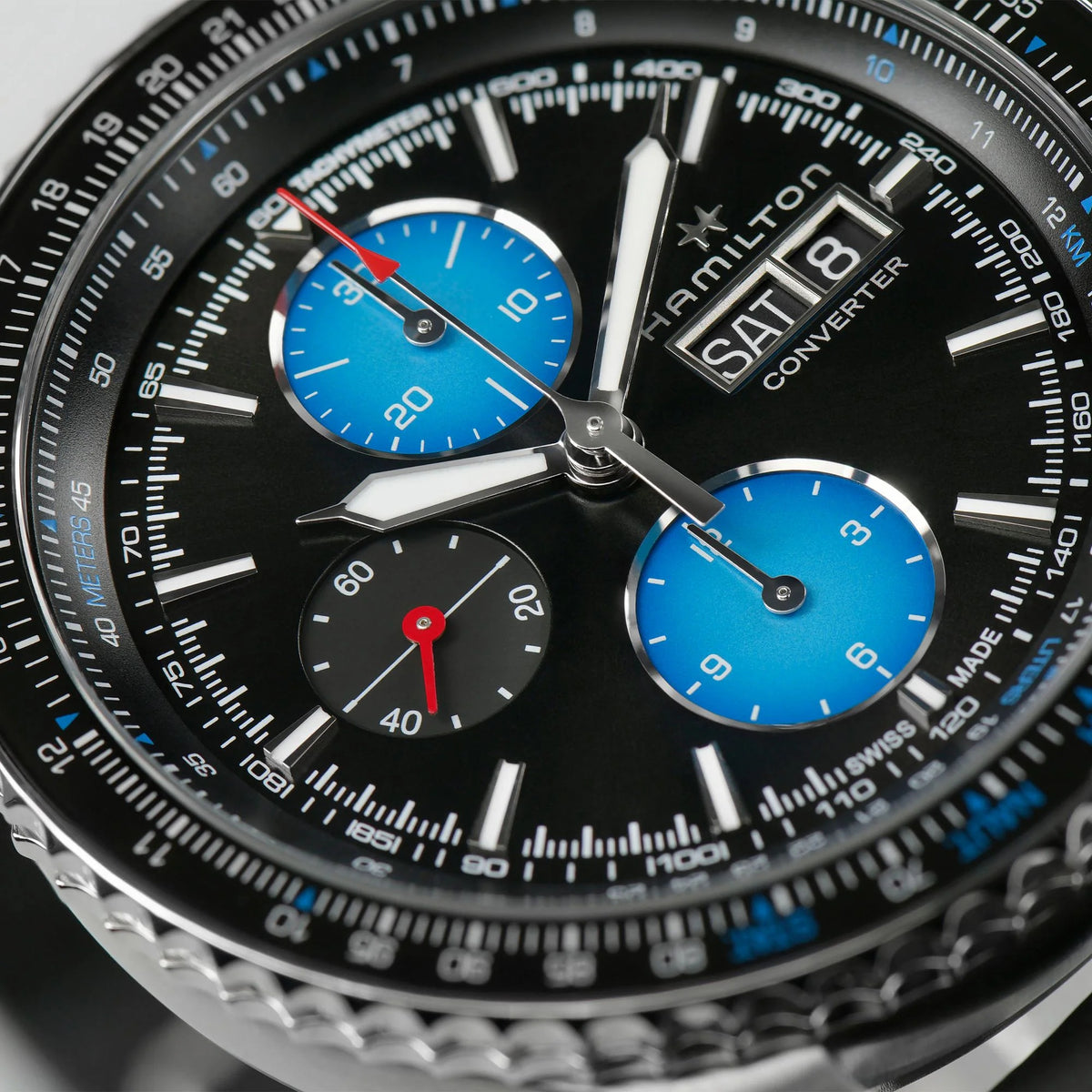 Men's automatic pilot watch close-up of black dial with blue subdials and date window
