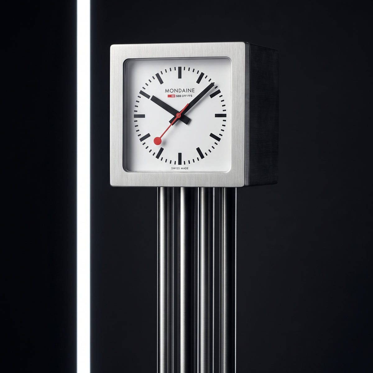 Square aluminum table clock with white dial, black markers, and red second hand