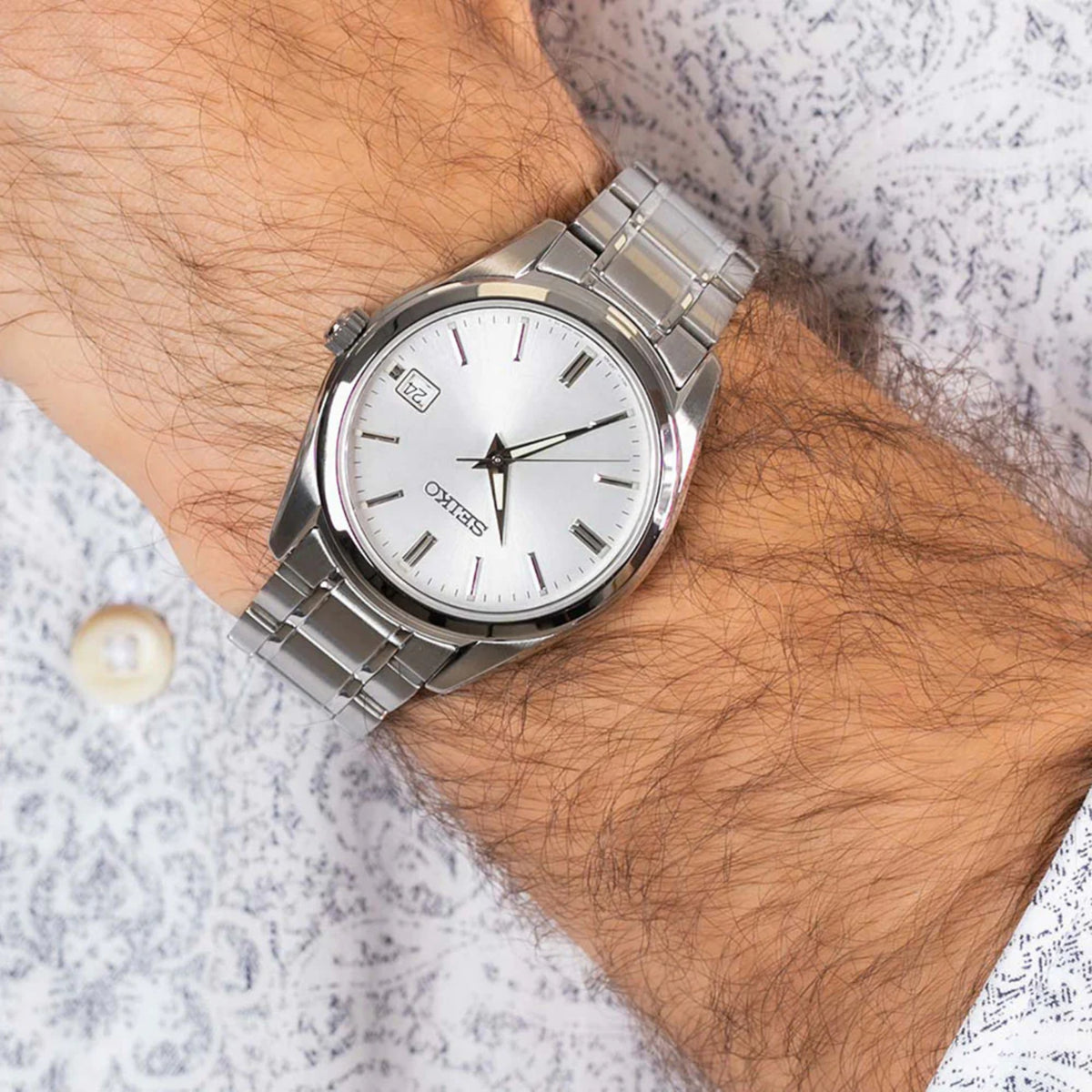 Seiko Essentials SUR307P1 silver dial watch worn on wrist with stainless steel bracelet