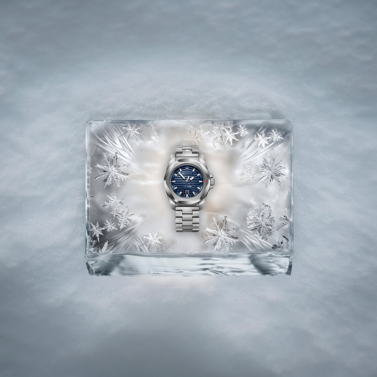 Victorinox I.N.O.X. blue dial automatic steel watch elegantly displayed on a transparent ice block surrounded by snowflakes in a frosty setting 