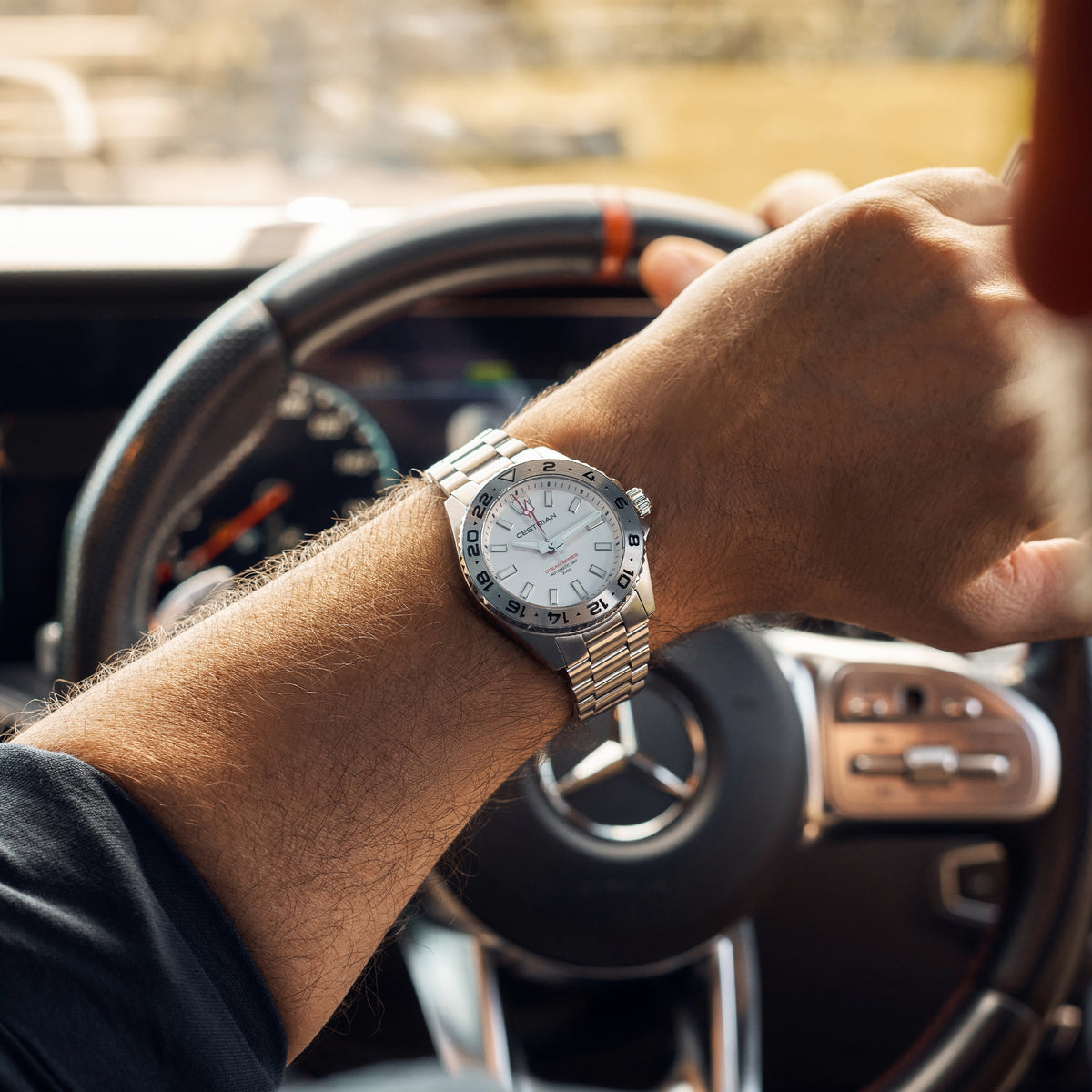 Men's silver-tone watch with white dial and steel bracelet, worn on wrist