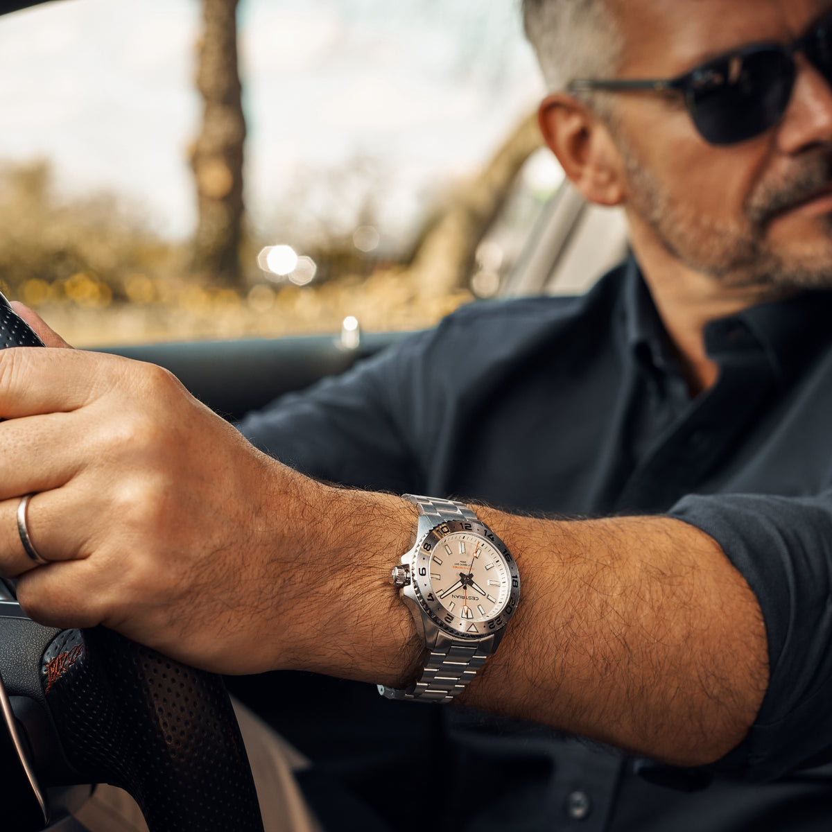 Men's steel bracelet watch with white dial, worn on wrist
