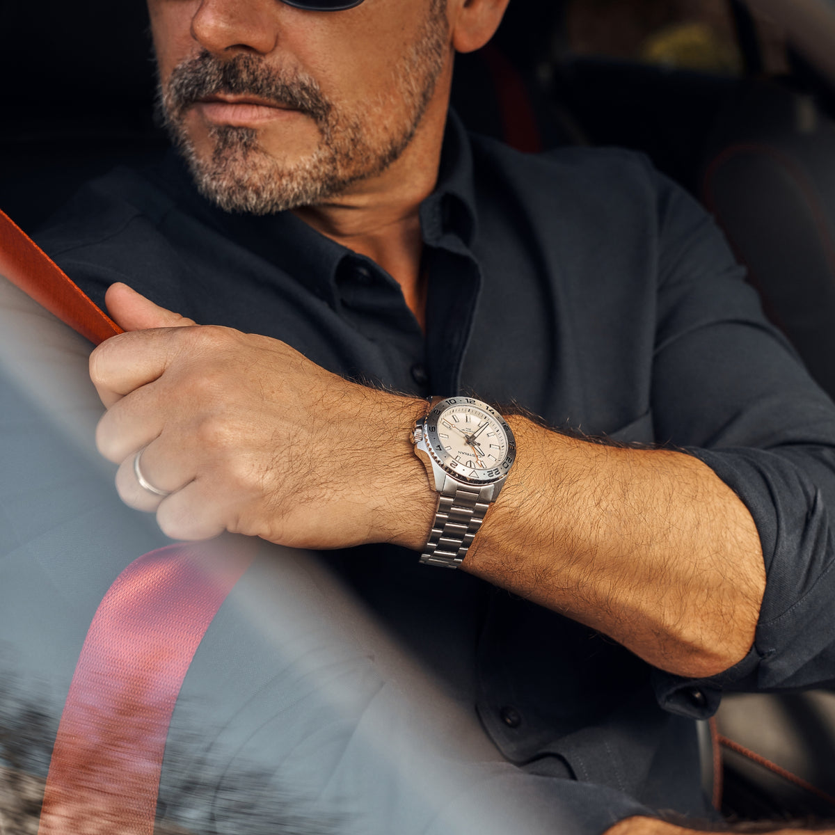 Men's steel bracelet watch with white dial and bezel markings, worn on wrist