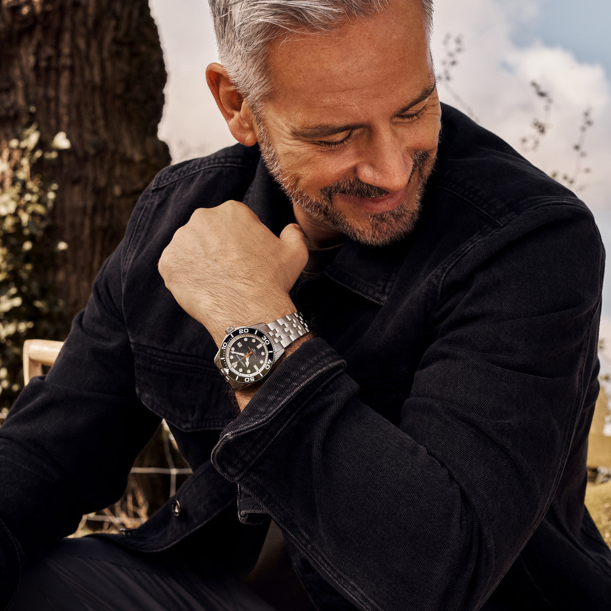 Men's automatic dive watch, black dial and silver link bracelet on wrist