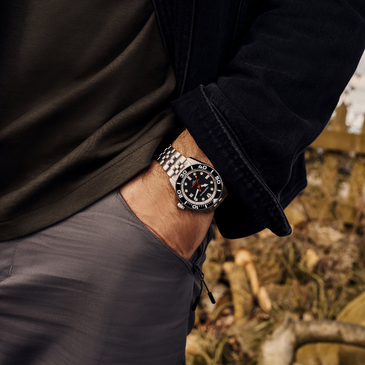 Men's black-dial dive watch with orange-toned accents, silver bracelet and bezel