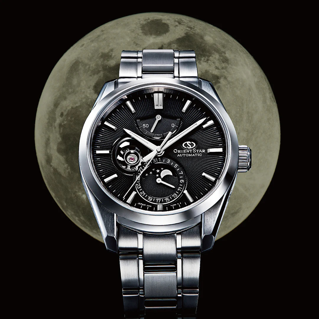 Orient Star executive automatic watch featuring a black open-heart dial, moonphase sub-dial, and power reserve indicator