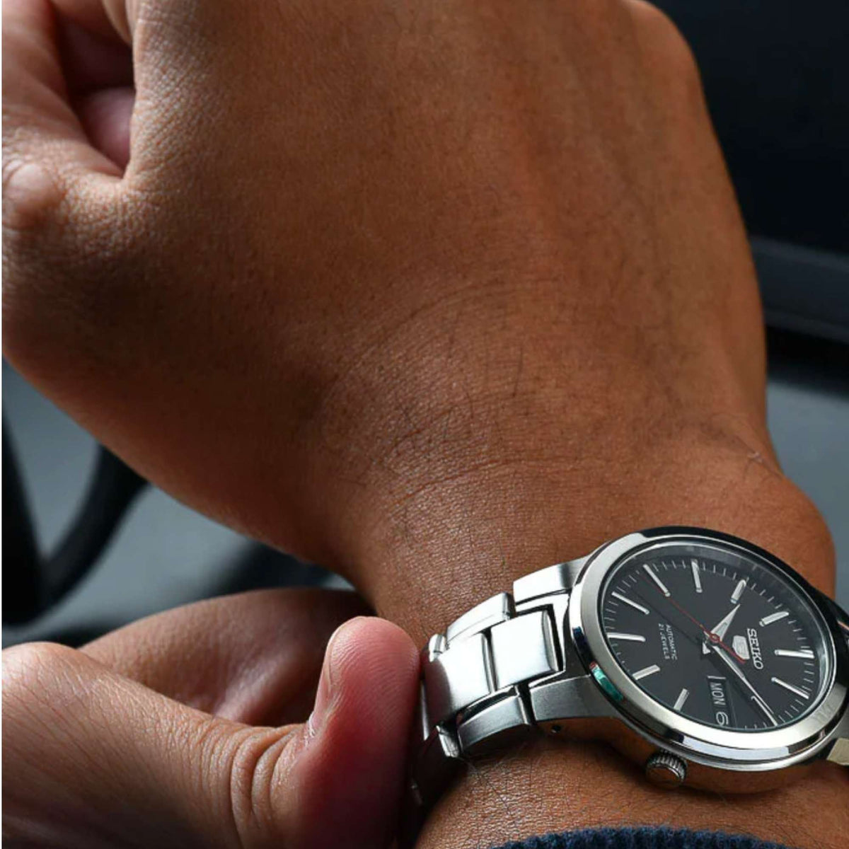 Seiko automatic men's watch on wrist, black dial with red seconds hand and date window