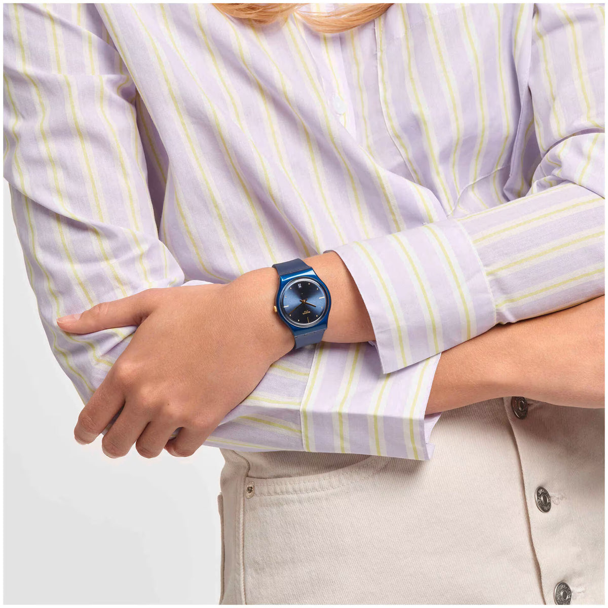 Blue quartz watch on wrist; round blue dial with gold hands, blue silicone strap